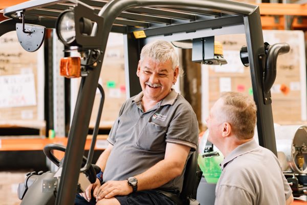Wesley Industries supported employment Worker in forklift talking to another worker