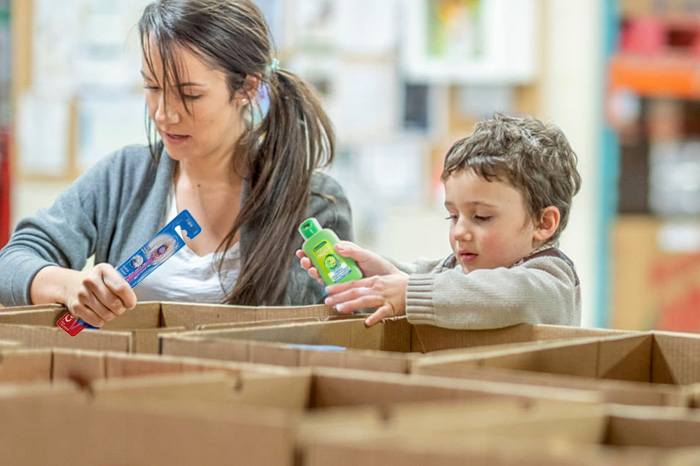 Mum and child packing toiletries donations