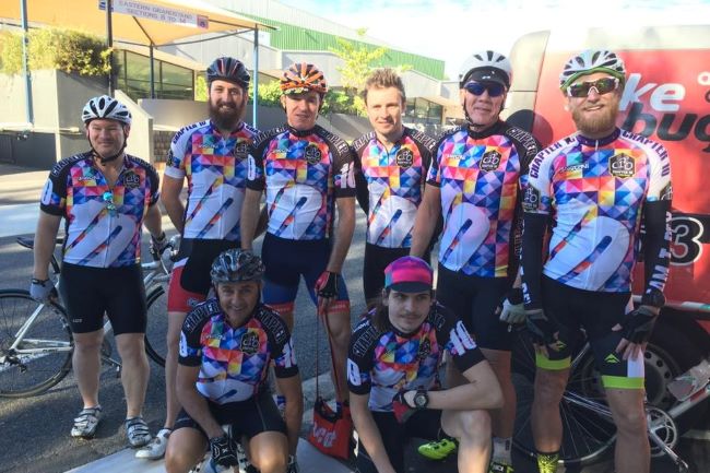 8 cyclists smiling group-wearing-cycling-clothes
