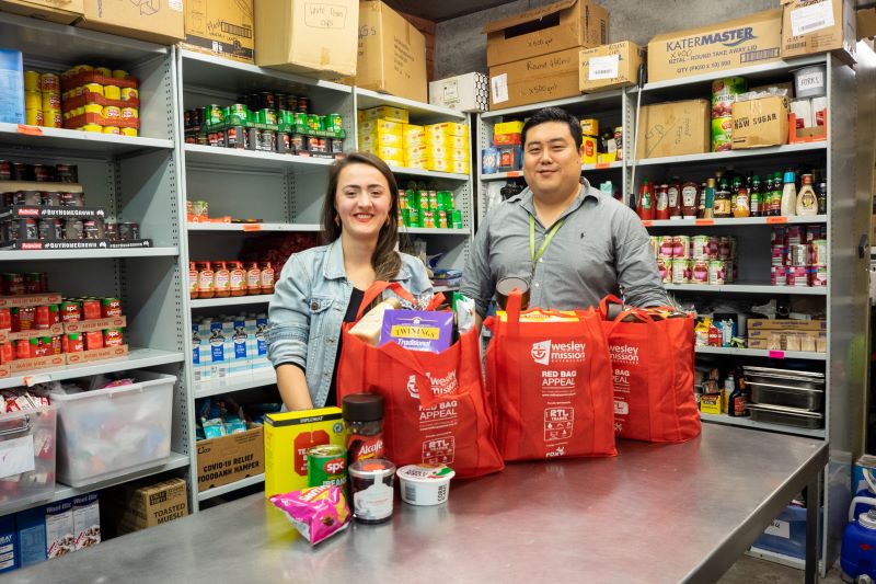 People filling Red Bags with groceries