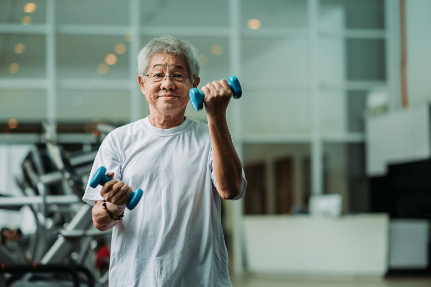 Senior Asian man exercising at a gym