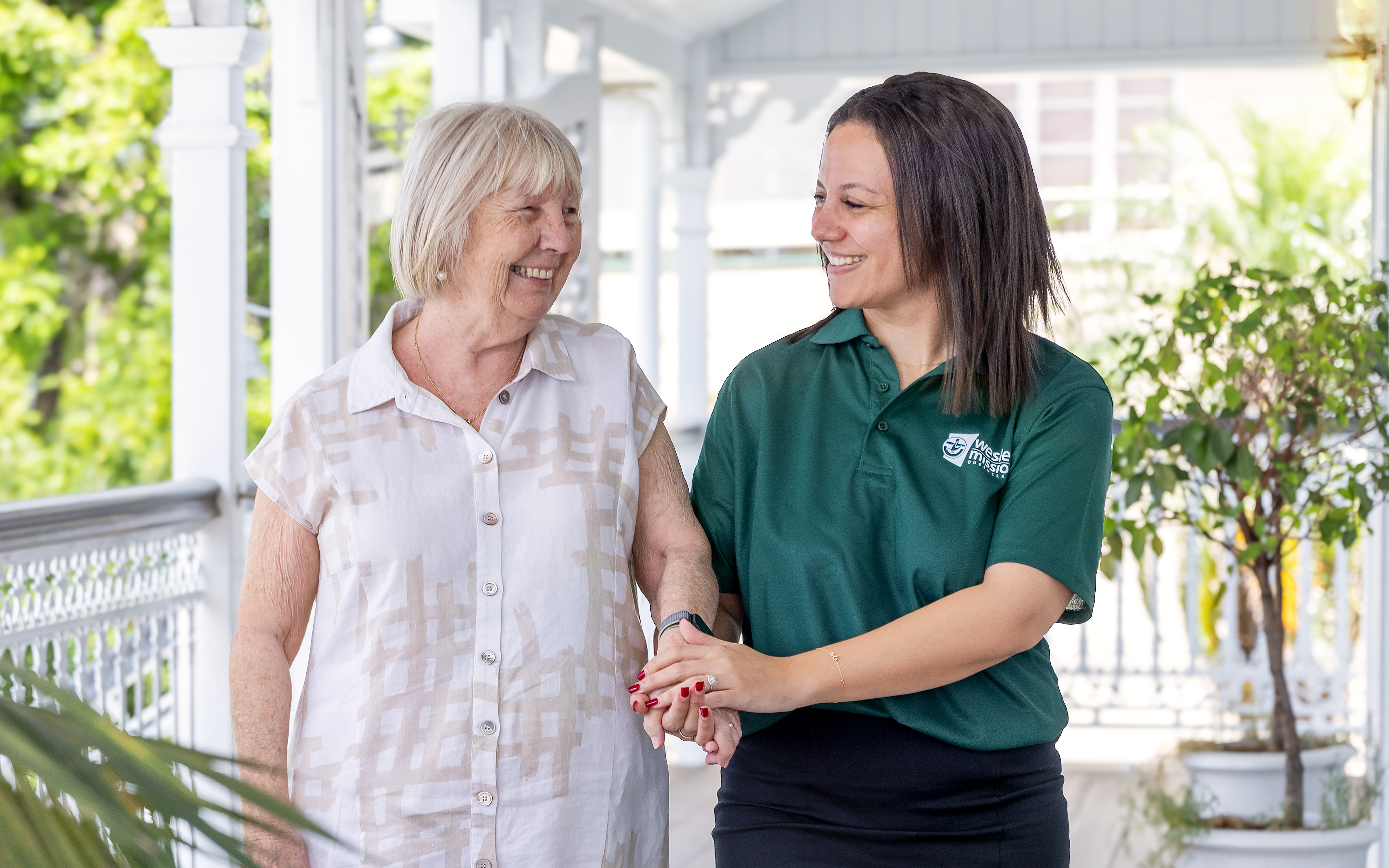 Home care worker smiling as she chats with a happy client at her Queenslander home