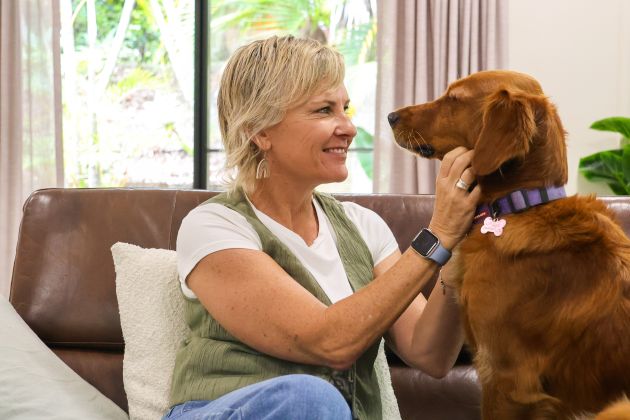 Woman smiling and patting dog