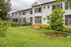 Exterior of building with grass, fence and seat