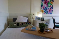 Comfortable bed with overbed table at Reid Court