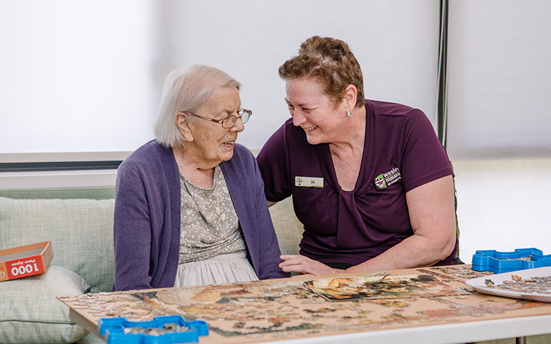 WMQ aged care worker plays puzzle with a resident WMQ aged care worker plays puzzle with a resident