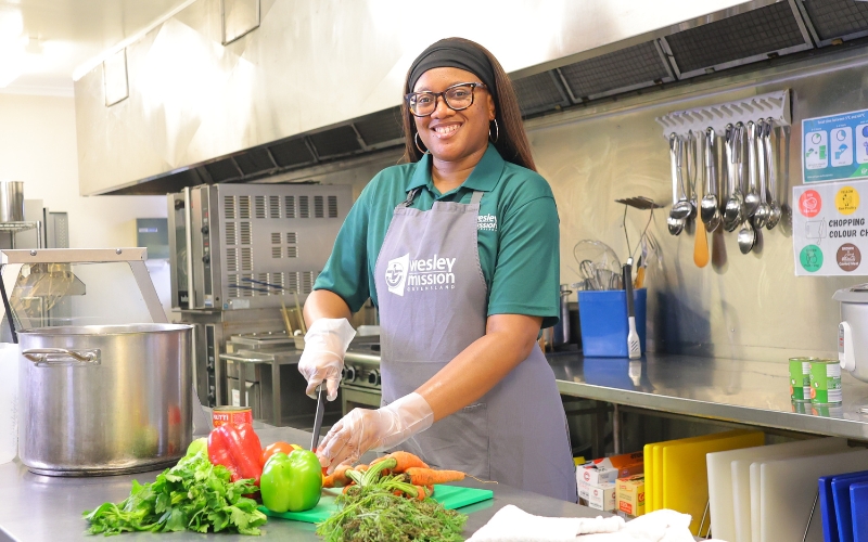 Chef smiling at camera and cutting vegetables